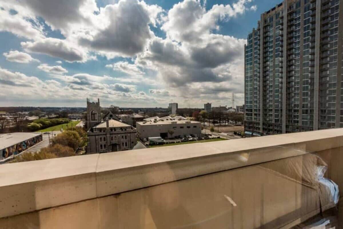 A high-rise building with a view of a historic building and a church in the background.
