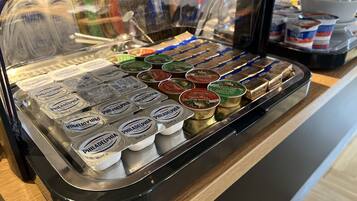 A variety of food items in a display case, including containers of Philadelphia cream cheese and other spreads.