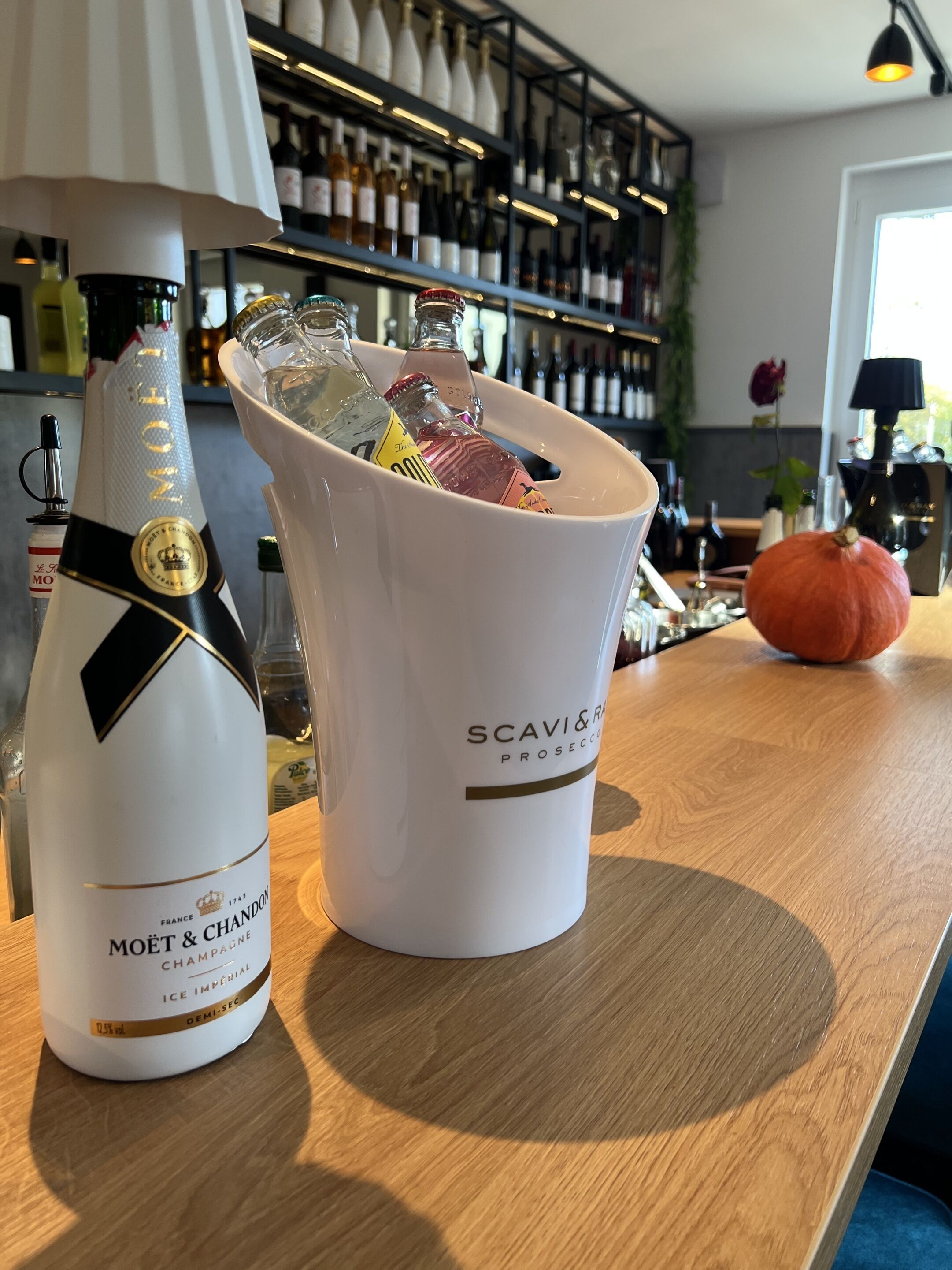 A bar area with a bottle of Moët & Chandon Champagne and a bucket labeled SCAVI&RICH.