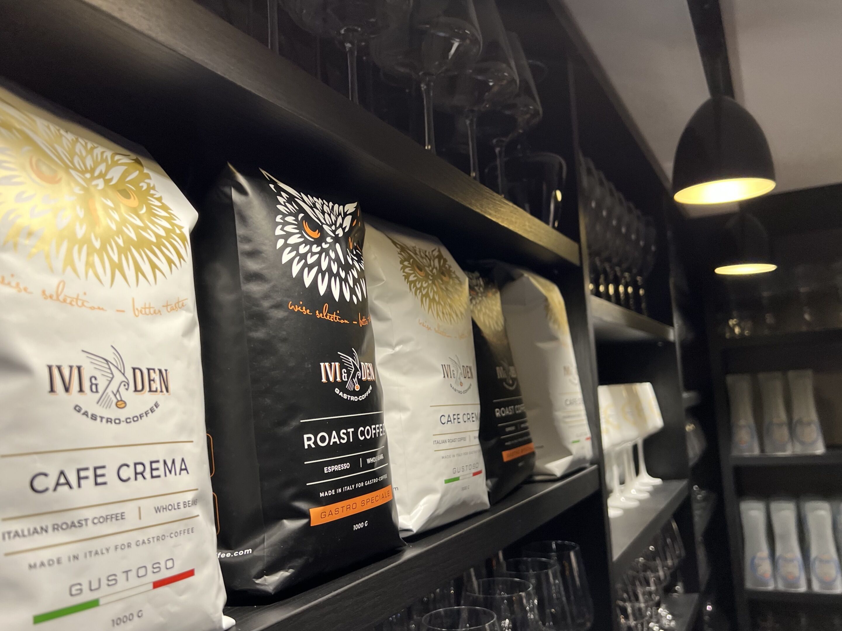 Regale voller Kaffeesäcken mit der Aufschrift 'Cafe Crema' und 'Roast Coffee'.