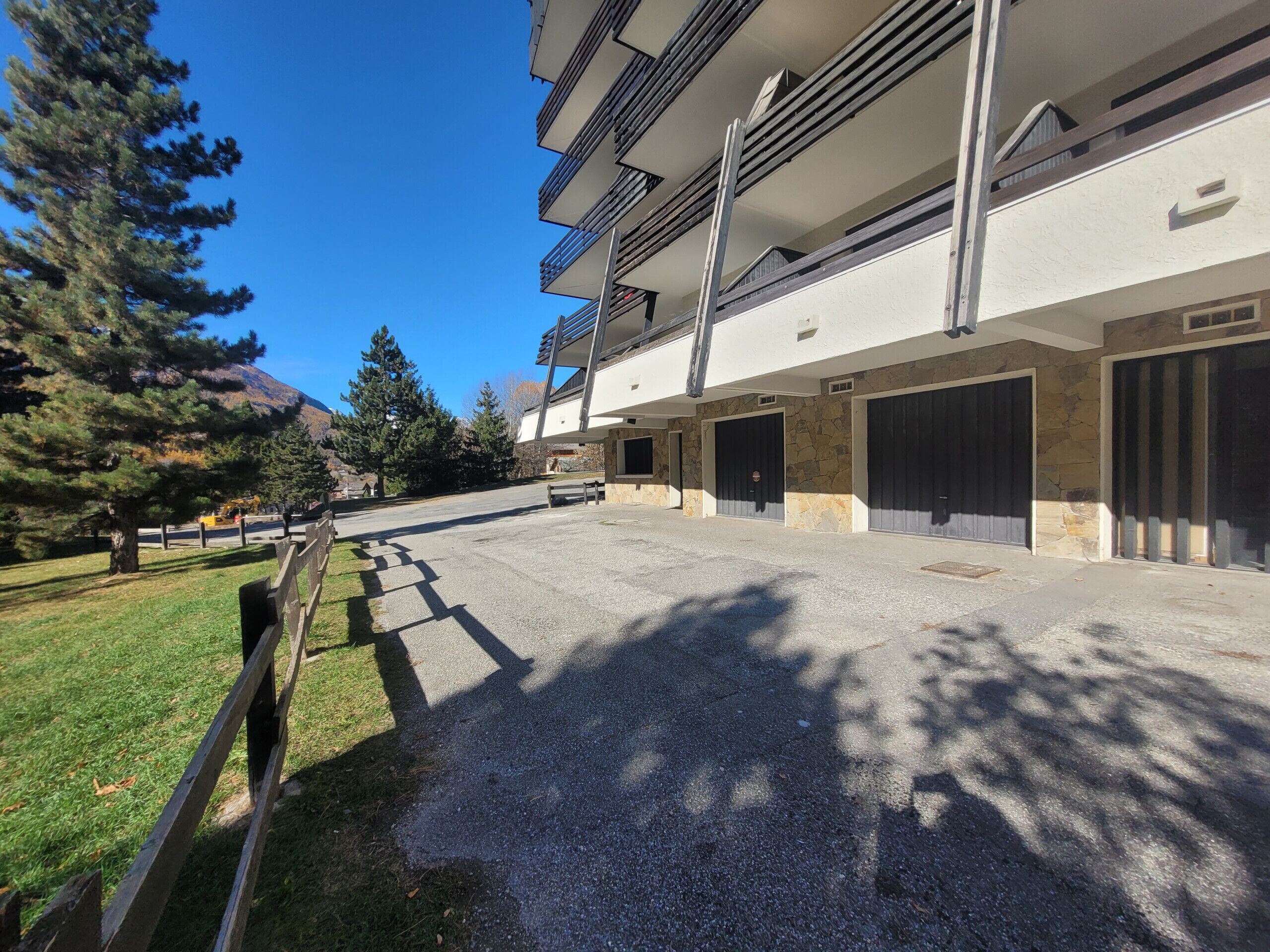 Un edificio a più piani con un'area di parcheggio di fronte.
