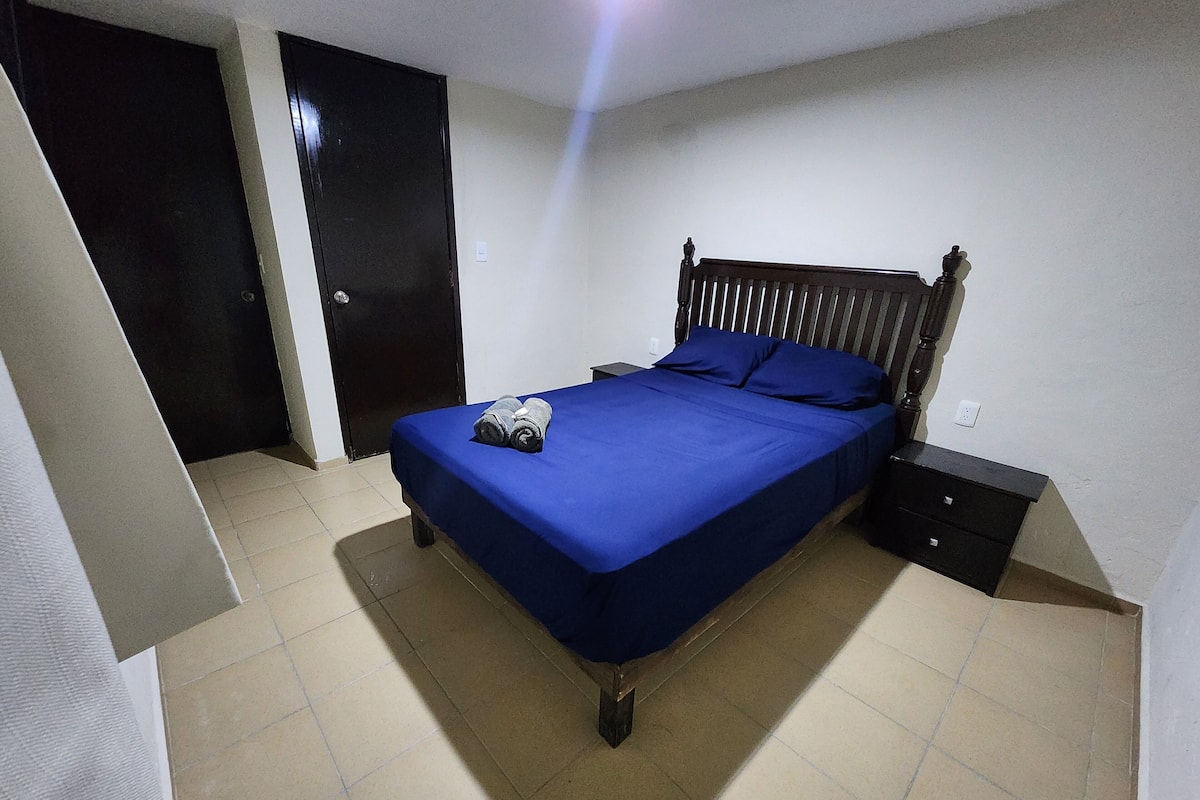 A bedroom with a bed, a nightstand, and a wardrobe.