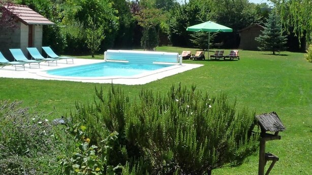 A backyard with a swimming pool, lounge chairs, and a small shed. - Le Verger du Sausset (Beaune)