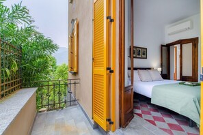 A room with a bed, a window, and a balcony with yellow shutters. - Villa Eugenia Suite 2 - MyHomeinComo (Carate Urio)