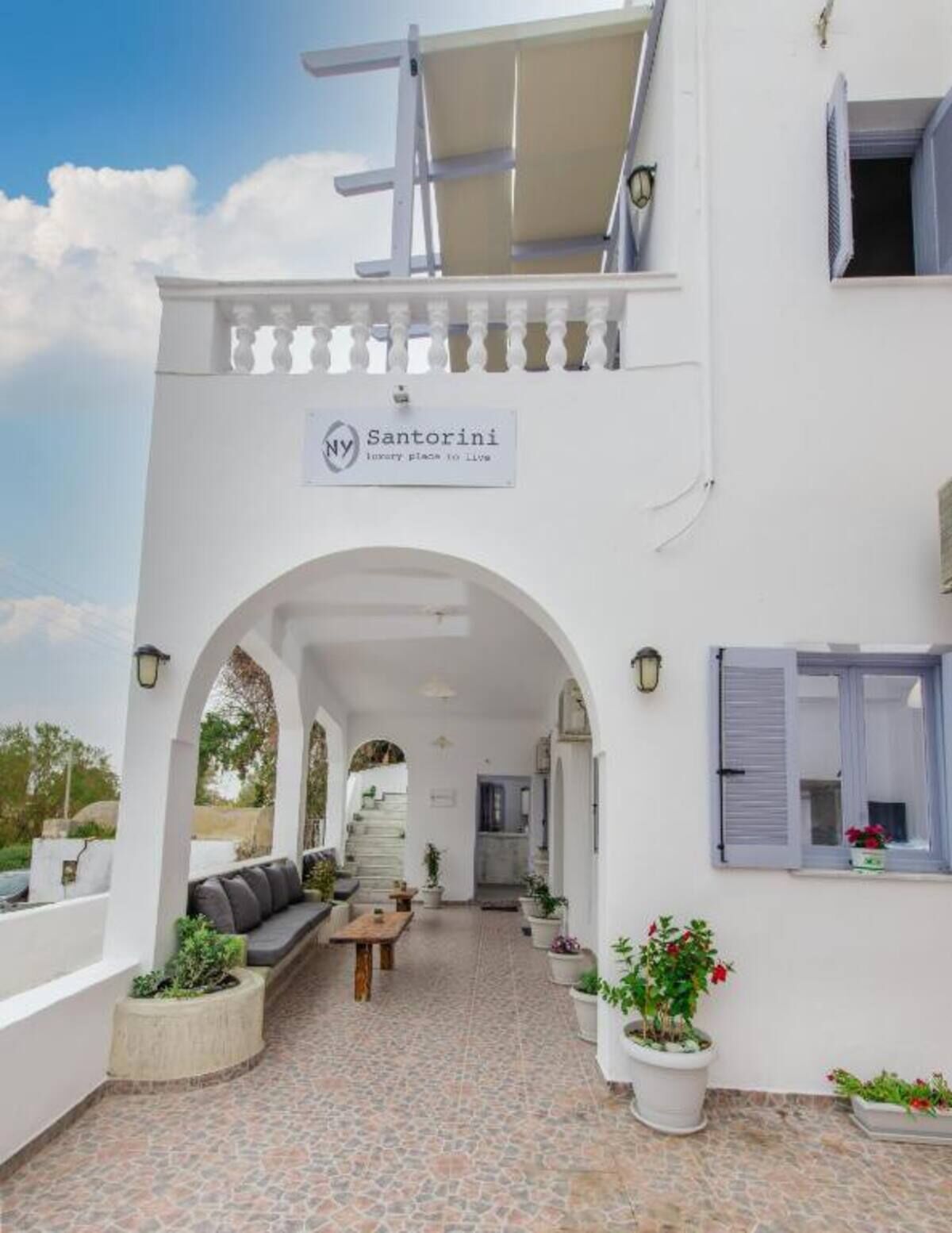 A white building with a sign reading 'Santorini luxury place to live.'