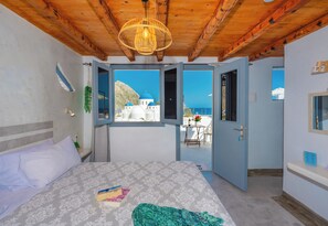 Un dormitorio con cama, ventana y vista a un edificio con cúpulas azules.