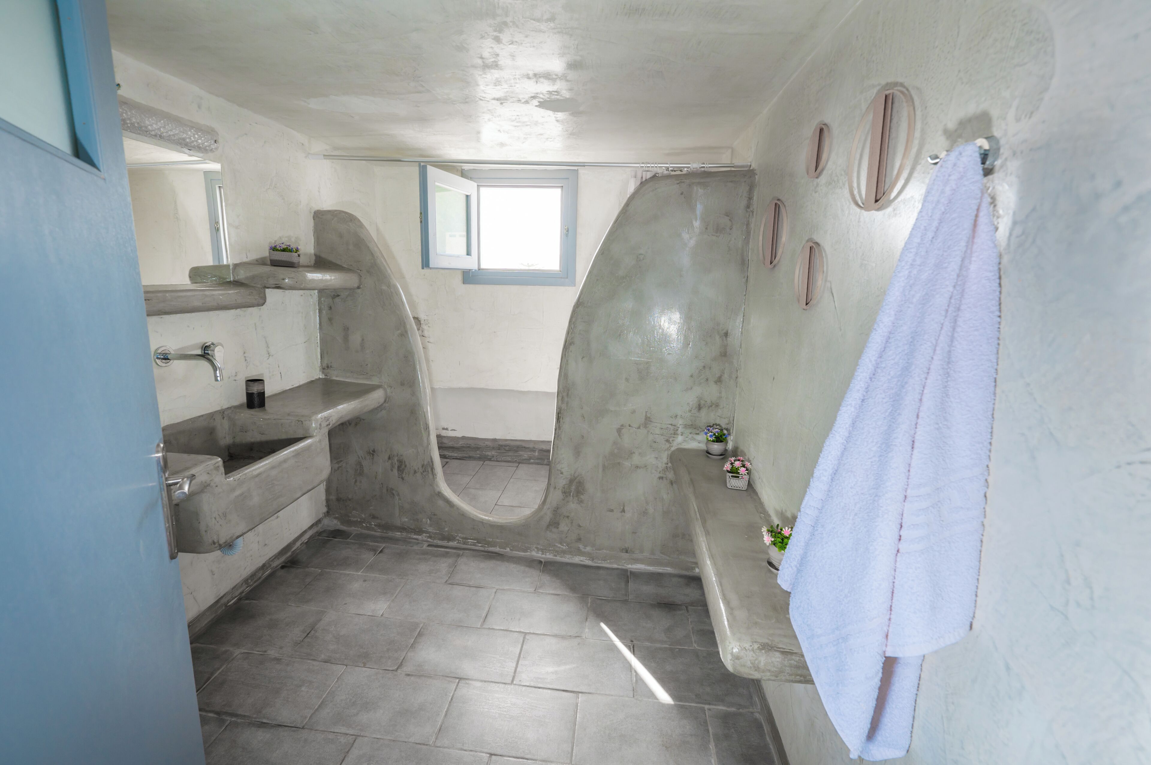 A bathroom with a bathtub, a sink, a window, and a towel hanging on the wall.