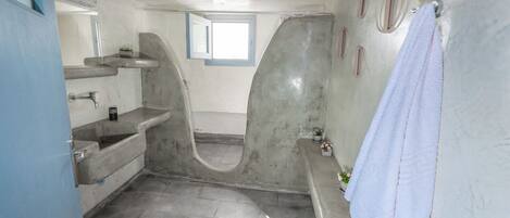 Un baño con bañera, lavamanos, ventana y una toalla colgada en la pared.