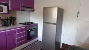 A compact kitchen with purple cabinets, a stainless steel refrigerator, a microwave, and a stove. - Lovely apartment with private pool - Rivière-Pilote (Martinique) (Rivière-Pilote)