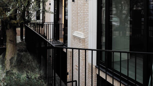 A building with large windows, a brick facade, and a black metal railing. - The Westview: 2BR Penthouse &Terrace in White City (London)