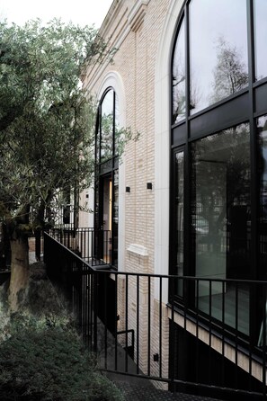 A building with large windows, a brick facade, and a black metal railing. - The Westview: 2BR Penthouse &Terrace in White City (London)
