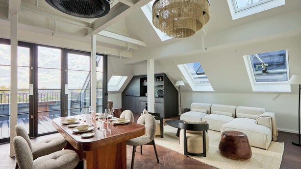 Un loft spacieux comprenant un coin repas, un canapé et une vue sur l’extérieur.