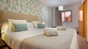 Un lit bien fait, avec des oreillers et une couverture, un mur à motifs, une fenêtre avec des rideaux et une porte en bois.