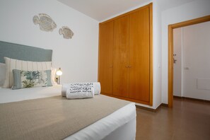 Une chambre à coucher avec un lit, une armoire en bois et une table de chevet avec une lampe.