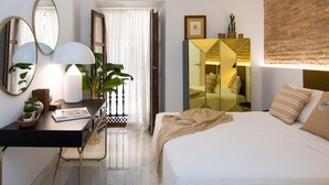 Ein modernes Hotelzimmer mit Bett, Nachttisch, Lampe, Spiegel und Kleiderschrank.