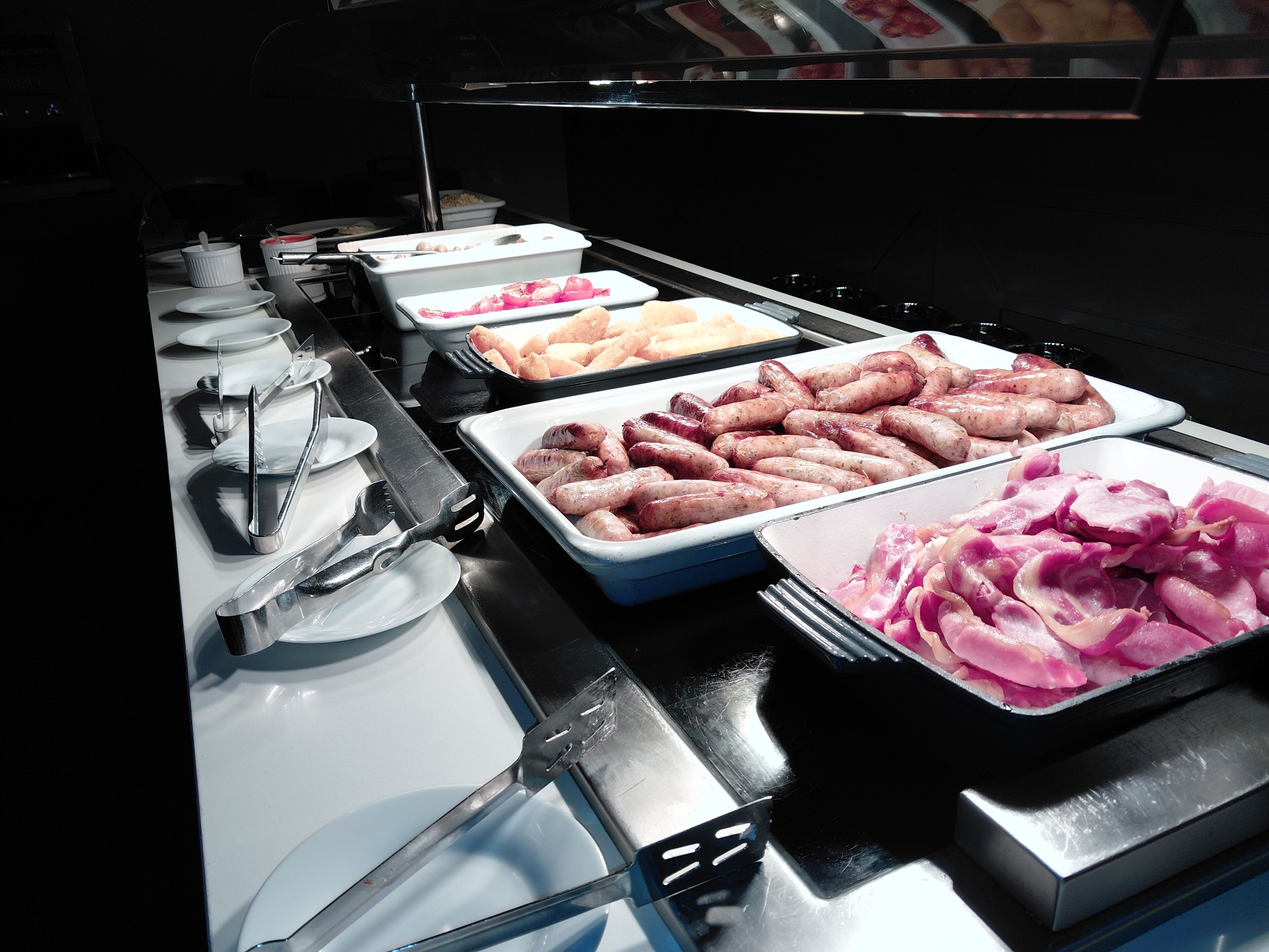 Un bufé con diversos alimentos, incluyendo carnes y verduras.