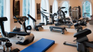 A gym with various exercise equipment, large windows, and a blue mat. - Brandon Hall Hotel and Spa (Coventry)