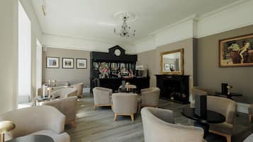 A spacious living room with a fireplace, a bar area, and a large mirror.