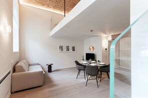Et moderne interiør med et spisebord, en sofa og en trappe.