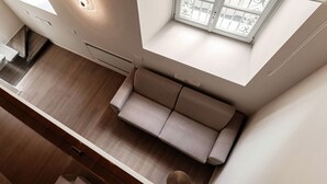 Eine moderne Küche mit integriertem Sofa, einem Fenster mit dekorativen Eisenstreben und einem Oberlicht.