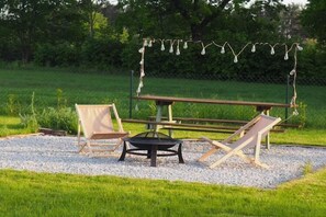 An outdoor seating area with a table, two chairs, and a fire pit. - Green Hill Domyslow, 6 persons (Kołczewo)