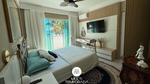 Un dormitorio moderno con cama, mesita de noche, televisión y vistas al exterior.