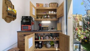 Eine kleine Küche mit Holzausstattung, einer Mikrowelle und einer Kaffeemaschine.