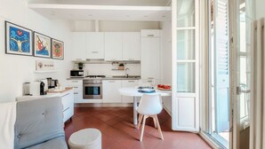 Una cucina moderna con mobili bianchi, un tavolo da pranzo con sedie e un'ampia finestra con vista.
