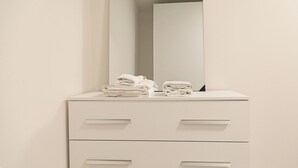 Un baño con un tocador blanco, un espejo y dos cajones.