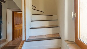 Una escalera con escalones de madera y una pared blanca.
