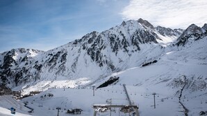 Ein mit Schnee bedeckter Berg mit Seilbahnen und blauem Himmel.
