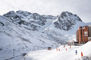 Una montagna innevata con una seggiovia e un edificio con la scritta 'Residence' sullo sfondo.