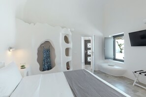 Un dormitorio moderno con cama, televisor, ventana y un diseño de pared único.