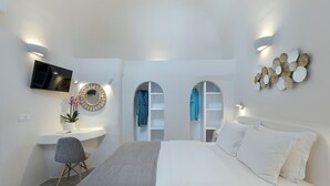Ein modernes Schlafzimmer mit Bett, Fernseher, Schreibtisch und Stuhl.