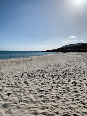 A beach with sand, water, and a distant hill. - Apartment 'Villa Marina' with Sea View, Shared Pool and Air Conditioning (Pula)
