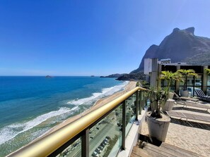 A balcony with a view of the ocean and a mountain. - São Conrado - Praia e tranquilidade (Rio de Janeiro)