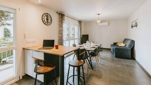 Una cocina moderna con comedor, sofá y televisión.