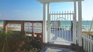 Portilla varustettu ranta-alueen sisäänkäynti, jossa on kyltit, joissa lukee: «Seashalls by the Sea» ja «Paradise Retreat».
