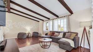 A modern living room with a sofa, a coffee table, and a bean bag. - 6BD Near DT - BBQ Grill, Games & Football Fun (Arvada)