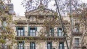 A multi-story building with a classical facade, multiple balconies, and storefronts at the ground level. - Welcome to The Penthouse – Beachfront Luxury (Barcelona)