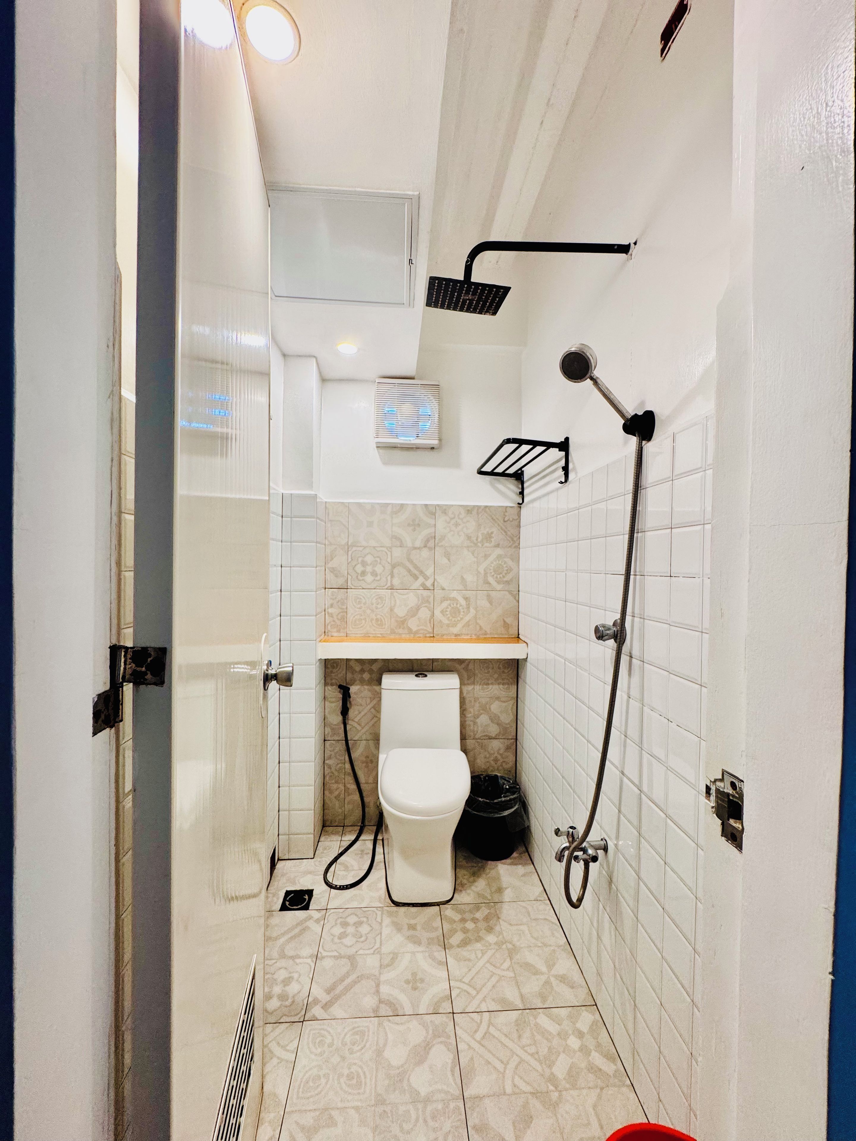 Un baño pequeño con inodoro, ducha y lavamanos.