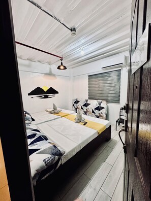 Een moderne slaapkamer met een groot bed, een plafondventilator en een raam met zonwering.