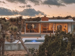 A modern house with a pool, surrounded by desert vegetation. - Looking Glass · Luxury Pool & Spa Villa (Yucca Valley)