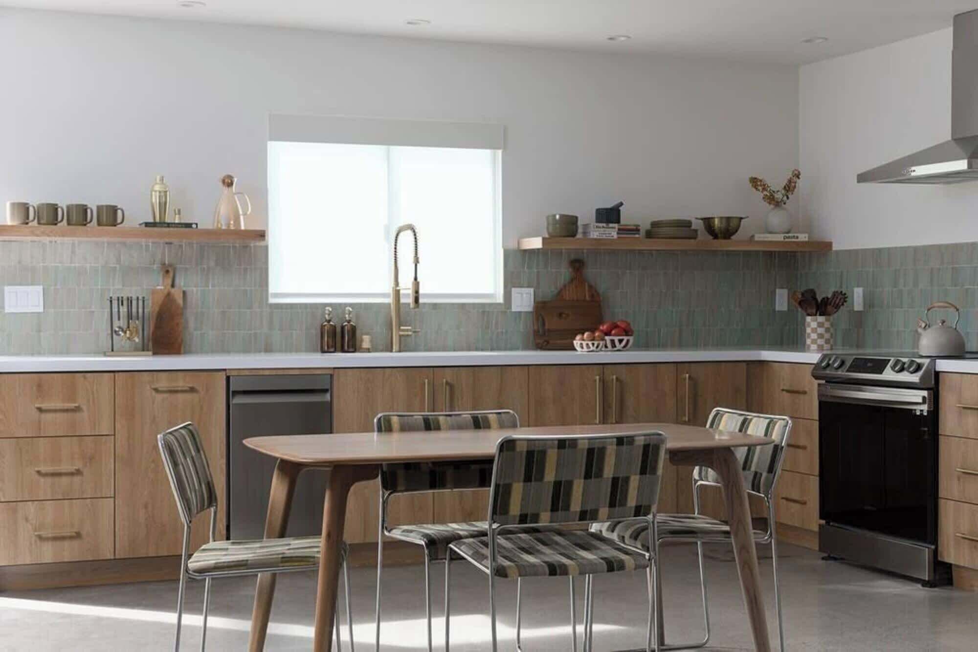 A modern kitchen with a central island, wooden cabinets, and stainless steel appliances.