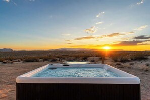 A hot tub in a desert landscape with a sunset in the background. - Noetic House · Hot Tub, Cowboy Tub, Views, 5 Acres (Joshua Tree)