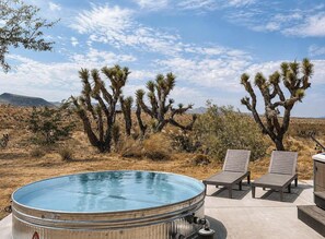 A hot tub with lounge chairs and a desert landscape with Joshua trees. - Pipes Canyon Homestead • Privacy, Epic Views, Spa (Yucca Valley)