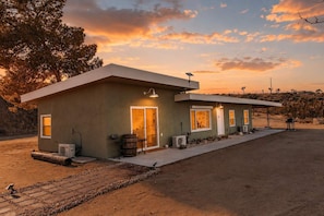 A modern two-story building with a flat roof, large windows, and a covered patio area. - Pipes Canyon Homestead • Privacy, Epic Views, Spa (Yucca Valley)