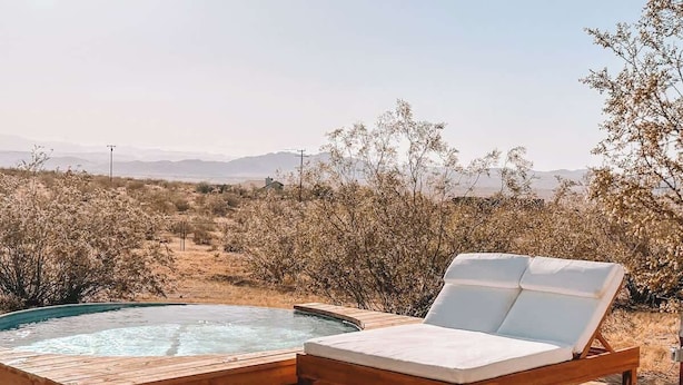 Un jacuzzi con muelle de madera y una silla de descanso.