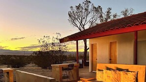 Un espacio al aire libre con zona de estar, hogar y una vista del paisaje.