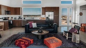 A modern kitchen with wooden cabinets, a large window, and a view of the landscape. - The Refuge • Healing Retreat, Saltwater Pool & Spa (Joshua Tree)